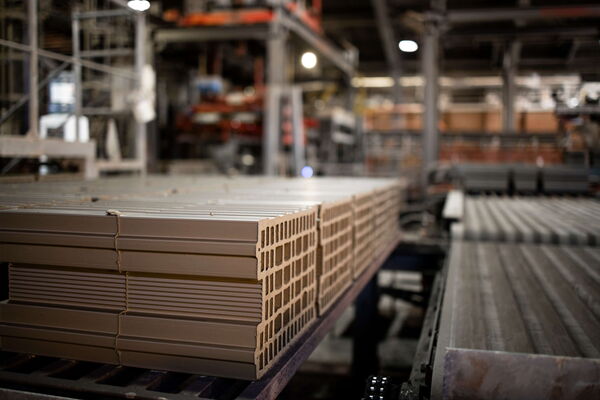Stacks of brown construction materials are organized in a busy manufacturing facility, showcasing efficient operations. (Text KI-generiert)