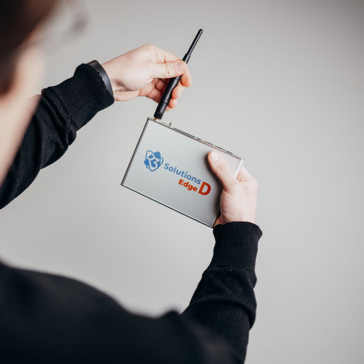 A person demonstrates the advanced functionality of the Edge D device, holding it with an antenna.
